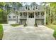 Beautiful raised home with large front porch, three garages, and mature landscaping at 2856 Claybrook St, Johns Island, SC 29455