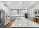 Bright kitchen features white cabinets, stainless steel appliances, and a large quartz island with pendant lighting at 2856 Claybrook St, Johns Island, SC 29455