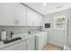 Efficient laundry room with white cabinets, sink, and washer and dryer set at 2856 Claybrook St, Johns Island, SC 29455
