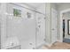 Bright white tiled walk-in shower with a bench and glass door at 2856 Claybrook St, Johns Island, SC 29455