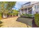 Landscaped backyard featuring a screened porch, lush greenery, and a well-maintained lawn at 301 Hidden Bottom Ln, Daniel Island, SC 29492