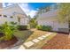 Serene backyard with stone pathway and neatly mulched garden beds separating home and garage at 301 Hidden Bottom Ln, Daniel Island, SC 29492