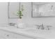 Bright bathroom vanity with double sinks, white marble countertop, and decorative greenery at 301 Hidden Bottom Ln, Daniel Island, SC 29492