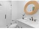 Modern bathroom featuring a frameless glass shower, a round mirror, and a stylish vanity at 301 Hidden Bottom Ln, Daniel Island, SC 29492