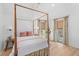The bright bedroom features a canopy bed, wood floors, and three windows to allow plenty of natural light at 301 Hidden Bottom Ln, Daniel Island, SC 29492
