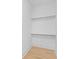 The simple, bright walk-in closet features painted wood floors and two metal racks to hang clothing at 301 Hidden Bottom Ln, Daniel Island, SC 29492