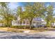 Corner view of a classic home featuring a sprawling porch and lush landscaping at 301 Hidden Bottom Ln, Daniel Island, SC 29492