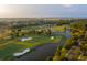 Scenic aerial of a verdant golf course with multiple sand traps, a small lake, and tree-lined fairways at 301 Hidden Bottom Ln, Daniel Island, SC 29492