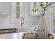 Detailed view of the kitchen sink with white cabinetry and countertop near a bright, sunlit window at 301 Hidden Bottom Ln, Daniel Island, SC 29492