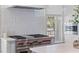 Modern kitchen featuring a high-end gas range, marble countertops, and stylish backsplash at 301 Hidden Bottom Ln, Daniel Island, SC 29492