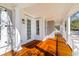 The covered front porch features hardwood floors, white columns, and white doors and windows at 301 Hidden Bottom Ln, Daniel Island, SC 29492