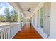 Expansive porch with wood flooring, white columns and railings, and a ceiling fan for outdoor enjoyment at 301 Hidden Bottom Ln, Daniel Island, SC 29492