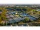 Aerial view of multiple tennis courts surrounded by lush greenery and landscaping with clubhouse in the center at 301 Hidden Bottom Ln, Daniel Island, SC 29492
