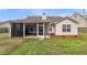 View of home exterior with screened in porch and grassy backyard on a sunny day at 311 Old Stone Ct, Moncks Corner, SC 29461