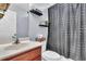 Bathroom features a wood cabinet vanity, toilet and shower with a gray curtain at 311 Old Stone Ct, Moncks Corner, SC 29461