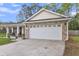 Exterior of home with brick accents, two car garage, and charming front porch at 311 Old Stone Ct, Moncks Corner, SC 29461