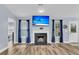 Cozy living room features a fireplace, TV, wood flooring, and natural light from two windows at 311 Old Stone Ct, Moncks Corner, SC 29461