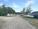 A community RV and boat storage area on a gravel lot surrounded by trees and blue sky at 311 Old Stone Ct, Moncks Corner, SC 29461
