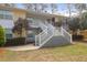 Two-story condo featuring stair access, landscaping, and mature trees on a sunny day at 341 W Coleman Blvd # F, Mount Pleasant, SC 29464