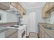 Galley kitchen with white appliances and light brown cabinets at 341 W Coleman Blvd # F, Mount Pleasant, SC 29464