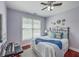 Well-lit secondary bedroom featuring a wrought iron bed frame, ceiling fan, and hardwood floors at 3805 Adrian Way, Mount Pleasant, SC 29466