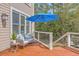 Inviting deck with a cozy seating area, an umbrella, and a view of the lush backyard at 3805 Adrian Way, Mount Pleasant, SC 29466