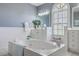 A large soaking tub in the main bathroom, with arched window and and sinks at 3805 Adrian Way, Mount Pleasant, SC 29466
