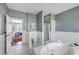 Well-lit main bathroom with soaking tub, glass shower, toilet, and access to the main bedroom at 3805 Adrian Way, Mount Pleasant, SC 29466