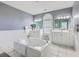 Bright main bathroom with a soaking tub, and sinks, large mirrors, and an arched window at 3805 Adrian Way, Mount Pleasant, SC 29466