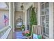 Cozy front porch featuring a hanging chair, potted plants, and patriotic decor, perfect for relaxation at 3805 Adrian Way, Mount Pleasant, SC 29466