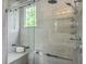Modern tiled shower with glass door, rainfall showerhead, and bench at 3805 Adrian Way, Mount Pleasant, SC 29466