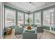 Light-filled sunroom with ceiling fan, tile flooring, comfortable seating and a view of the well landscaped yard at 3805 Adrian Way, Mount Pleasant, SC 29466