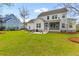 Spacious backyard features a patio with outdoor seating and a well-maintained lawn with trees and blue house nearby at 3873 Newhall St, Mount Pleasant, SC 29466