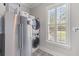 A modern laundry room features stacked washer and dryer units, plus storage, and natural light at 3873 Newhall St, Mount Pleasant, SC 29466