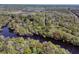 Wide aerial shot of river cutting through trees with a small home along riverbank at 394 Shoofly Rd, Ridgeville, SC 29472