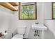 Cozy bathroom features a toilet, sink, window and wall shelves, creating a functional space at 394 Shoofly Rd, Ridgeville, SC 29472