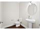 Contemporary powder room featuring pedestal sink, round mirror, and dark hardwood floors at 404 Ambergate Ln, Moncks Corner, SC 29461