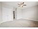 Carpeted bedroom featuring neutral walls, ceiling fan, closet, and entry door at 404 Ambergate Ln, Moncks Corner, SC 29461