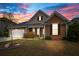 Charming home featuring colorful sky, well-manicured lawn, landscaping, covered porch, and two car garage at 404 Ambergate Ln, Moncks Corner, SC 29461