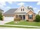 Charming single story home featuring well-manicured lawn, landscaping, covered porch, and two car garage at 404 Ambergate Ln, Moncks Corner, SC 29461