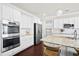 A spacious kitchen with hardwood floors, an island with seating, stainless steel appliances, and white cabinetry at 404 Ambergate Ln, Moncks Corner, SC 29461