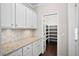 This pantry features hardwood floors, granite countertops and bright white cabinetry at 404 Ambergate Ln, Moncks Corner, SC 29461