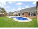 Backyard features a kidney-shaped pool, green grass, and a covered patio at 404 Ambergate Ln, Moncks Corner, SC 29461