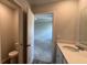 View into the bathroom with toilet and sink vanity, and view into the carpeted bedroom at 405 Mistflower Ln, Moncks Corner, SC 29461