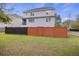 View of a two-story home with neutral siding and a partial privacy fence dividing the yard at 4120 Veritas St, Charleston, SC 29414