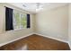 This light-filled bedroom features hardwood floors, large window with black curtains, and a ceiling fan at 4120 Veritas St, Charleston, SC 29414