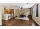 Bright dining area with wood floors, a stone accent wall, and access to a modern kitchen with granite countertops at 4120 Veritas St, Charleston, SC 29414