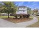 Two-story home with landscaped yard featuring mature trees and bushes on a corner lot at 4120 Veritas St, Charleston, SC 29414