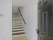 Stairwell with wooden steps, handrail, and black front door leading to the upper floors at 4120 Veritas St, Charleston, SC 29414