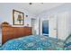 View of a bed with a floral pattern and a view to the bathroom with a blue shower curtain at 45 Sycamore Ave # 116, Charleston, SC 29407